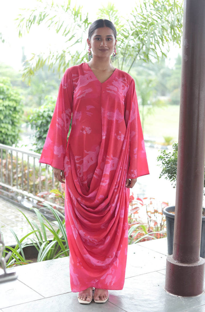 Woman wearing Mush Clothing pink gown with a floral pattern in drape style