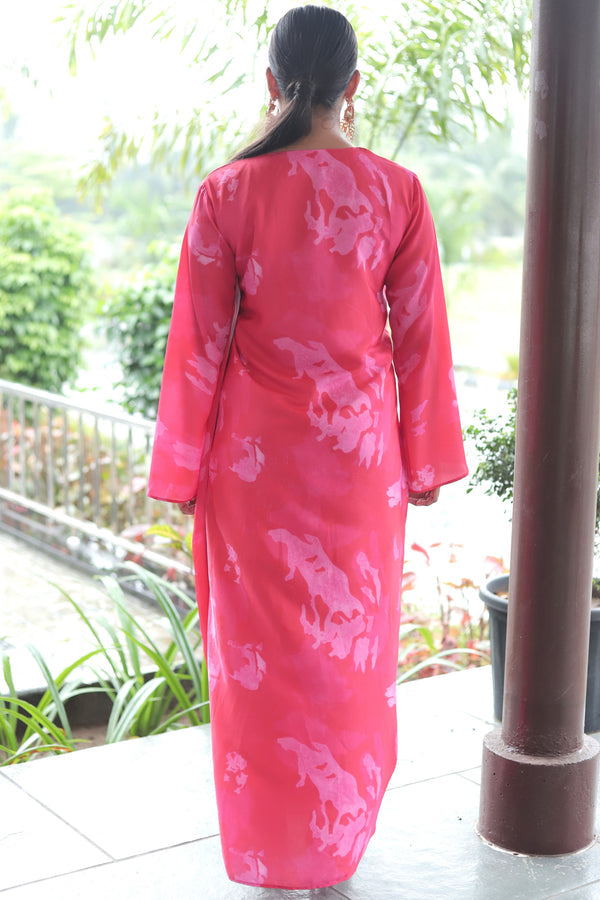 Woman wearing Mush Clothing pink gown with a floral pattern in drape style